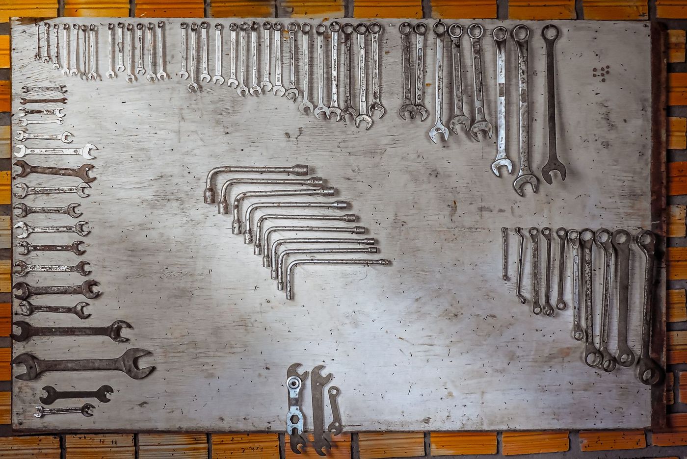 An organised board of spanners laid out by size in a workshop — stock photograph